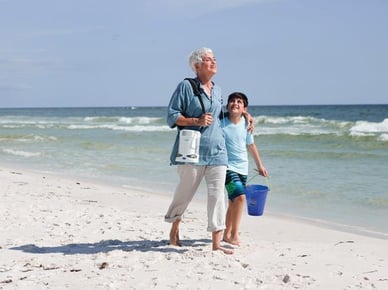 Woman walking with portable oxygen concentrator.