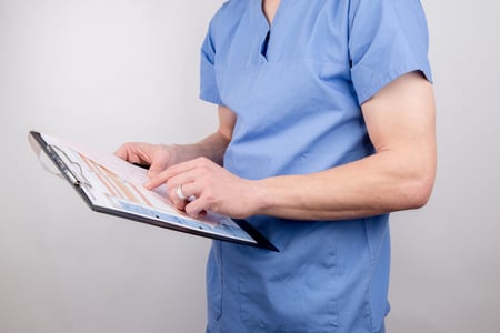 Doctor writing on a clipboard.