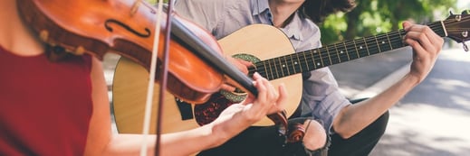 Man and woman playing violin and guitar.