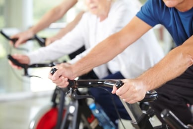 Men and women exercising on stationary bikes.