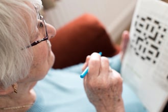 Old woman doing a cross word puzzle.