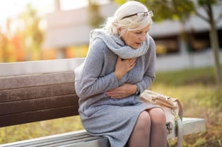 Woman holding her chest in pain.