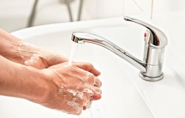 Man washing his hands in the sink.