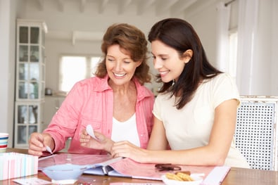 Two women creating a scrapbook together.