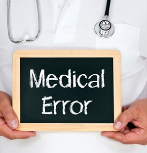 Doctor holding a sign that says "medical error."