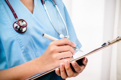 Doctor writing on a clipboard.