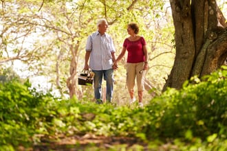 Man and woman walking through a forest.