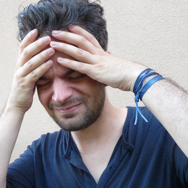 Man holding hands to his head.