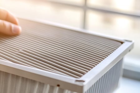 hand-replacing-hepa-filter-better-air-quality-indoors