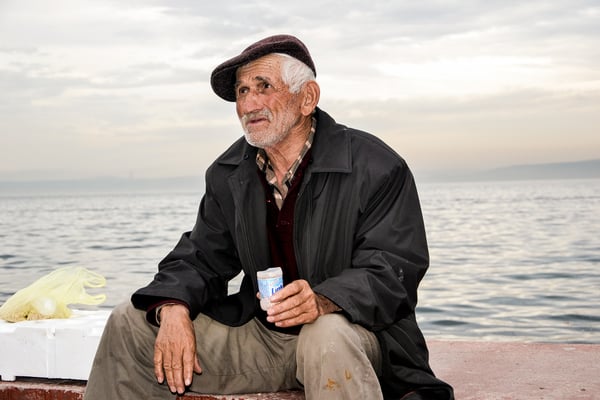 Man sitting near a body of water.