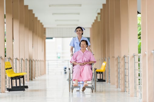 nurse pushing woman in wheelchair.