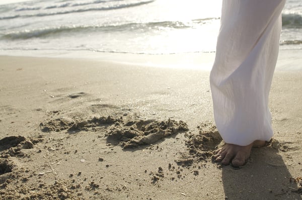 Woman standing on a beach.