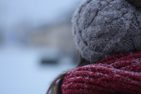 Woman standing in the cold with a wool scarf.