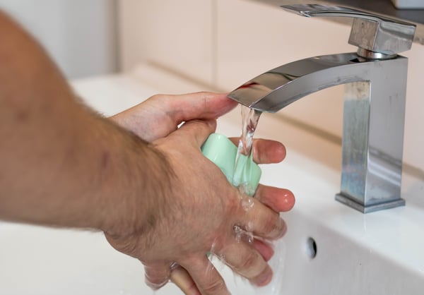 Washing hands with a bar of soap.