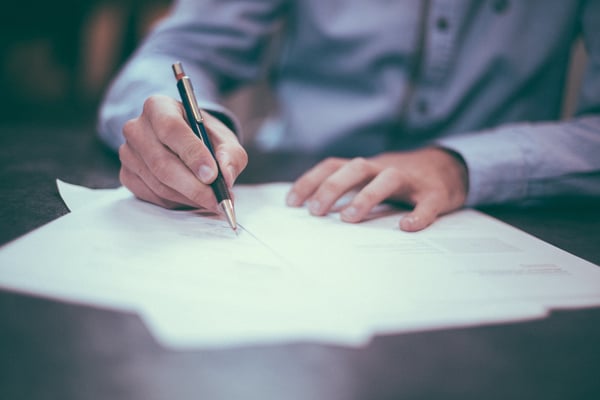 Man signing a document.